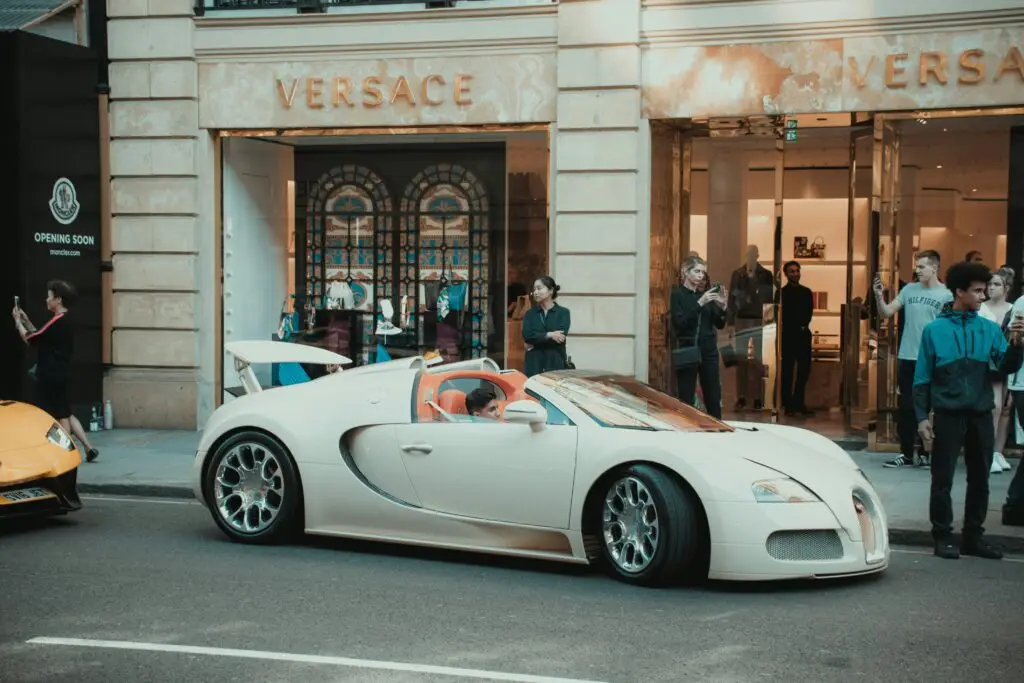 Luxury cars parked outside Versace store.