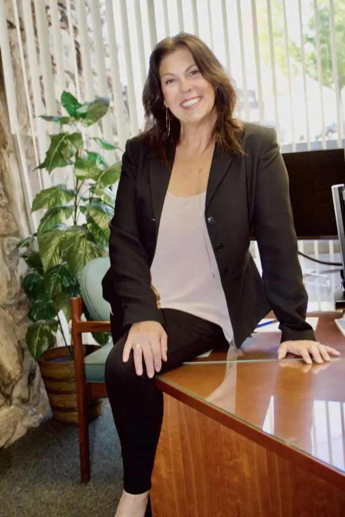 Smiling woman in business attire at office.